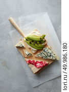 Top view of different kinds of colorful sandwiches represented on white chalkboard background. Party starter or appetizer - flat lay composition. Sandwiches with avocado, cheese, etc.. Sandwiches on white chalkboard. Стоковое фото, агентство Ingram Publishing / Фотобанк Лори