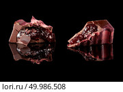Two cut candy with jam on a black background. section of delicious chocolates candies. Стоковое фото, агентство Ingram Publishing / Фотобанк Лори