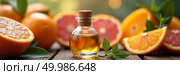 Closeup photograph of a small glass bottle filled with golden essential oil surrounded by vibrant citrus fruits on a rustic wooden surface. Стоковое AI-изображение, AI-художник Андрей Бакусов / Фотобанк Лори