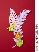 Calaveras attribute of the Mexican holiday of Calaca and handcraft paper colored leaves on a red background with copy space for text. Creative Halloween postcard.. A colorful paper composition of various colored leaves and Calaveras attribute of the Mexican holiday of Calaca on a red background with space for text. Halloween handcraft postcard. Flat lay. Стоковое фото, агентство Ingram Publishing / Фотобанк Лори