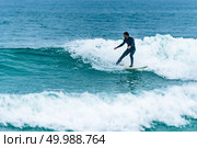 Surfer in action on the ocean waves on a cloudy day. Стоковое фото, агентство Ingram Publishing / Фотобанк Лори