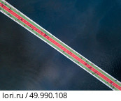 Aerial top view of people are walking on the pedestrian bridge and Dnieper river from above in city Kyiv , Ukraine. Drone photo. Aerial top view of pedestrian and cycling path lane on Park bridge and Dnieper river from above in city Kyiv , Ukraine. Стоковое фото, агентство Ingram Publishing / Фотобанк Лори