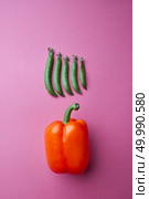 A set of different peas and juicy orange peppers on a rose paper background with copy space. Food composition. Top view. Composition of organic vegetables, ripe peppers and pea pods on a pink paper background. Top view. Стоковое фото, агентство Ingram Publishing / Фотобанк Лори