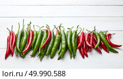 Homegrown organic colorful spice chili peppers on white wooden background with copy space, flat lay. a colorful mix of the freshest and hottest chili peppers on wooden table. Стоковое фото, агентство Ingram Publishing / Фотобанк Лори