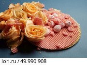 Circle waffles with orange roses. Waffles as decoration of navy blue background. Many roses of orange color represented on waffles.. Waffles as decoration of background. Стоковое фото, агентство Ingram Publishing / Фотобанк Лори