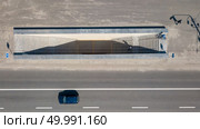 A view from above on a city road with a car and an underground passage along which a cyclist rides in Kyiv city, Ukraine. Aerial view on the of expressway across city road with an underground passage in the Kiev city. Редакционное фото, агентство Ingram Publishing / Фотобанк Лори