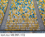 KIEV, UKRAINE - July 19, 2018. National Sports Complex Olimpiysky, aerial view from drone on empty even rows tribunes of stadium with yellow and blue seats before soccer match in the summer time.. KYIV, UKRAINE - July 19, 2018. Empty tribunes of NSC Olimpiysky in blue and yellow colors before the soccer game. Редакционное фото, агентство Ingram Publishing / Фотобанк Лори
