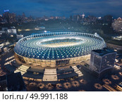 Kiev, Ukraine - May 21: Aerial night view of Football stadium Olimpiyskiy National Sports Complex. In white Grand Stadium passed the 2018 UEFA Champions League Final.. Kiev, Ukraine - May 21: Aerial night view of Olimpiyskiy National Sports Complex in Kiev. Редакционное фото, агентство Ingram Publishing / Фотобанк Лори