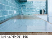 View of the kitchen with white hob, blue tile and metal sink. View of the kitchen with white hob. Стоковое фото, агентство Ingram Publishing / Фотобанк Лори