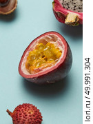 Fresh tropical half of passion fruit with delicious pulp and with lychee and dragon fruit on a blue background. Half of passion fruit with litchi and dragon fruit on a blue background. Стоковое фото, агентство Ingram Publishing / Фотобанк Лори