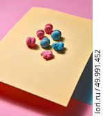 Pink bright macaroons are presented in the form of a triangular pyramid on yellow cardboard and one crushed macaroon on a pink paper background with reflection of shadows. Creative composition. Original composition of colorful macaroons on a yellow paper on paper background. Стоковое фото, агентство Ingram Publishing / Фотобанк Лори