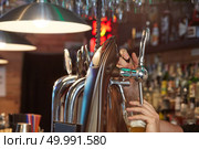 Barman hands pouring a lager beer in a glass.. Barman pouring beer. Стоковое фото, агентство Ingram Publishing / Фотобанк Лори