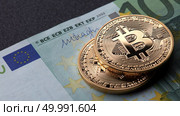 Two gold coins bitcoin stack on paper euro bill. Investing in crypto currency. Exchange bitcoin cash for a dollar.. Two gold coins bitcoin stack on paper euro bill. Стоковое фото, агентство Ingram Publishing / Фотобанк Лори