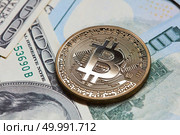 Gold coin bitcoin on dollar bills background. Cryptocurrency and blockchain concept.. Gold coin bitcoin on dollar bills background. Стоковое фото, агентство Ingram Publishing / Фотобанк Лори