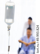 Set iv fluid intravenous drop saline drip in hospital room with patient and doctor in background. Стоковое фото, агентство Ingram Publishing / Фотобанк Лори