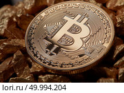 Macro shot of golden bitcoin coin on the mound of gold nuggets as digital gold concept. Bitcoin is a cryptocurrency and worldwide payment system, first decentralized digital currency. Close up golden bitcoin coin on the mound of gold nuggets. Cryptocurrency concept. Стоковое фото, агентство Ingram Publishing / Фотобанк Лори