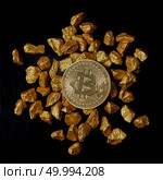 Bitcoin laying on stacked gold nuggets rendered on black background flat lay. Bitcoin as desirable as digital gold concept. Bitcoin cryptocurrency.. gold nuggets and Gold Bitcoin Coin on black background. Bitcoin cryptocurrency. Стоковое фото, агентство Ingram Publishing / Фотобанк Лори