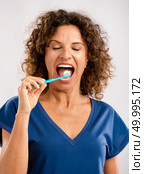 Beautiful mature woman brushing her teeths . Стоковое фото, агентство Ingram Publishing / Фотобанк Лори