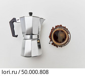 Italian coffee maker and the cup of fresh fragrant coffee beverage on a white background with copy space. Flat lay. The cup of morning coffee and italian metal maker on a white background. Morning coffee concept. Top view. Стоковое фото, агентство Ingram Publishing / Фотобанк Лори