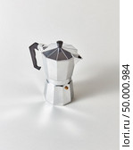 Metal geyser coffee maker presented on gray background with copy space.. Traditional metal Italian coffee maker presented on a gray background with copy space. Стоковое фото, агентство Ingram Publishing / Фотобанк Лори