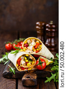 Burritos wraps with chicken meat and vegetables on wooden background. Стоковое фото, агентство Ingram Publishing / Фотобанк Лори