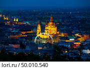 Ferris wheel and St Stephen basilica in Budapest illuminated at dusk. Стоковое фото, агентство Ingram Publishing / Фотобанк Лори