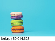 Cake macaron or macaroon on turquoise background from above, colorful almond cookies, pastel colors, vintage card. Стоковое фото, агентство Ingram Publishing / Фотобанк Лори