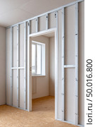 Constructing interior walls with metal studs in new room. Стоковое AI-изображение, AI-художник Юрий Поздников / Фотобанк Лори