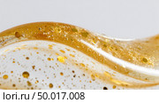 Shimmering gold and clear gel with glitter particles. Стоковое AI-изображение, AI-художник Юрий Поздников / Фотобанк Лори