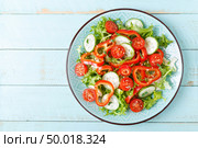 Healthy vegetarian vegetable salad of fresh lettuce, cucumber, sweet pepper and tomatoes. Vegan plant-based food. Flat Lay. Top view. Стоковое фото, агентство Ingram Publishing / Фотобанк Лори