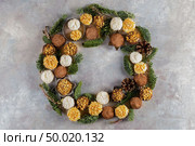 Homemade chocolate truffles with cocoa powder, coconut, walnuts as decorative Christmas wreath over grey texture background. Top view, copy space. Стоковое фото, агентство Ingram Publishing / Фотобанк Лори