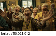 A group of elderly women joyfully singing and clapping their hands in unison. Стоковое AI-изображение, AI-художник Данила Большаков / Фотобанк Лори