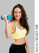 Beautiful sporty woman doing exercises with weights. Стоковое фото, агентство Ingram Publishing / Фотобанк Лори