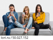 Happy teen girls at home using cellphone. Стоковое фото, агентство Ingram Publishing / Фотобанк Лори