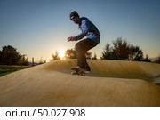 Skateboarder practice on a pump track park on a sunny summer day. Стоковое фото, агентство Ingram Publishing / Фотобанк Лори