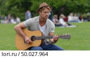 Musician playing acoustic guitar in park. Стоковое AI-видео, аниматор Юрий Поздников / Фотобанк Лори