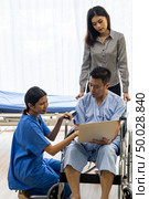 Physical therapist explain treatment method to senior patient and relative using notebook. Стоковое фото, агентство Ingram Publishing / Фотобанк Лори
