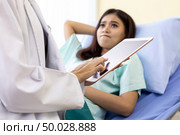 Patient fell worry when Asian Doctor make routine health check in hospital ward. Стоковое фото, агентство Ingram Publishing / Фотобанк Лори