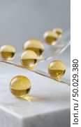 Golden serum capsules rolling on transparent strip on white marble. Стоковое AI-видео, аниматор Юрий Поздников / Фотобанк Лори