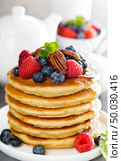 Stack of fluffy pancakes with fresh berries and pecan nuts. Стоковое фото, агентство Ingram Publishing / Фотобанк Лори