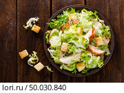 Caesar salad with grilled chicken meat, fresh lettuce, parmesan cheese and fried croutons. Classic North American cuisine. Top view. Стоковое фото, агентство Ingram Publishing / Фотобанк Лори