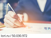 Close up hands signing terms of agreement documents of businessman on his desk, business signing concept. Стоковое фото, агентство Ingram Publishing / Фотобанк Лори