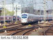 Railway station with modern high speed train in motion in the evening in Nuremberg, Germany. White train on the railroad track. Стоковое фото, агентство Ingram Publishing / Фотобанк Лори