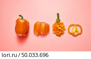 A set of different pieces and a whole ripe orange pepper with a green stem on a color background of the year 2019 Living Coral Pantone. Vegetarian Healthy Food Concept. Top view. Juicy fresh natural pepper sliced and whole on a color background of the year 2019 Living Coral Pantone. Flat lay. copy space. Стоковое фото, агентство Ingram Publishing / Фотобанк Лори