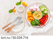 Vegetarian Buddha bowl with hummus and vegetables, top view. Стоковое фото, агентство Ingram Publishing / Фотобанк Лори