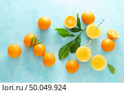Orange freshly squeezed juice in glass and fresh fruits on a blue vivid background, top view . Стоковое фото, агентство Ingram Publishing / Фотобанк Лори