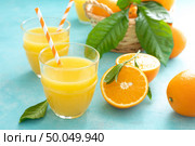Orange freshly squeezed juice in glass and fresh fruits on a blue vivid background. Стоковое фото, агентство Ingram Publishing / Фотобанк Лори