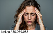 Introspective woman in gray top expressing stress and concentration in soft lighting. Стоковое AI-изображение, AI-художник Андрей Бакусов / Фотобанк Лори