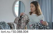 Portrait of young woman at home choosing right shirt to wear. Стоковое видео, видеограф Яков Филимонов / Фотобанк Лори