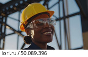 Confident engineer smiling on construction site with steel framework in background. Стоковое AI-видео, аниматор Владимир Федоров / Фотобанк Лори